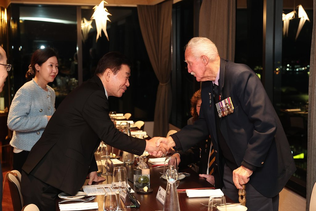 National Assembly Speaker Kim Jin-pyo shakes hands with a Korean War veteran before an event held at a hotel in New Zealand on Monday. (Yonhap)