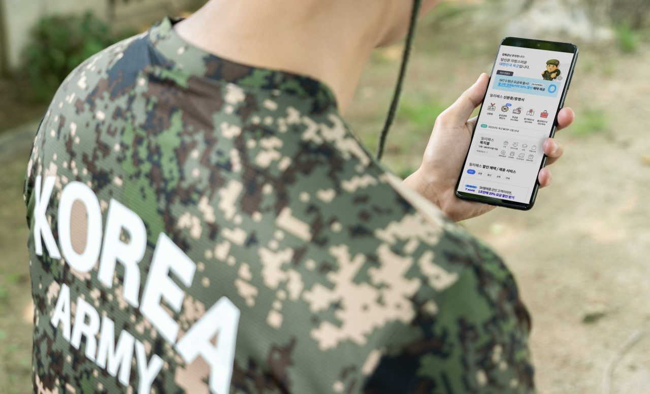 A soldier looks at an app that offers various benefits to soldiers with certified identification on a smartphone. (SK Telecom)