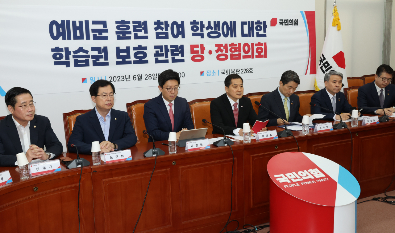 Government officials and ruling People Power Party lawmakers hold a meeting at the National Assembly on Wednesday. (Yonhap)