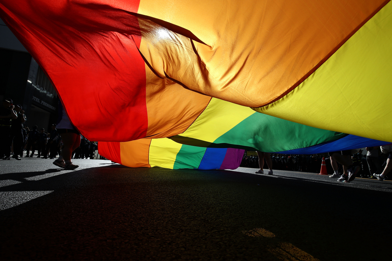 People wave a rainbow pride flag during the Korea Queer Culture Festival in front of City Hall on July 14, 2018 in Seoul. The annual festival promoting LGBTQ+ rights had occasionally been disrupted by anti-LGBT groups in the past, though homosexuality is not illegal in the country. (Getty Images)