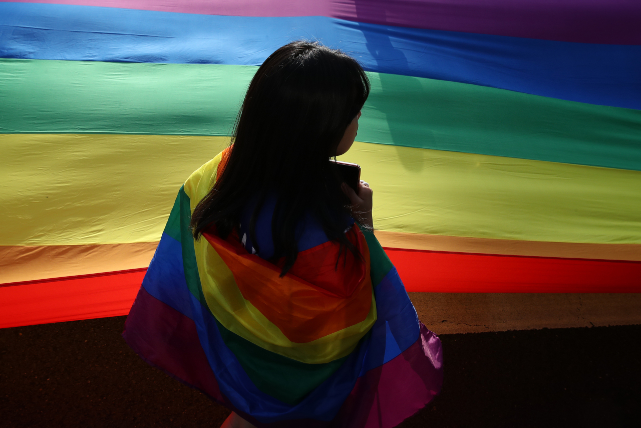 A South Korean holds a rainbow pride flag at the Korea Queer Culture Festival in front of City Hall on June 1, 2019, in Seoul. The annual festival promoting LGBTQ+ rights had occasionally been disrupted by anti-LGBT groups in the past, although homosexuality is not illegal in the country. (Getty Images)