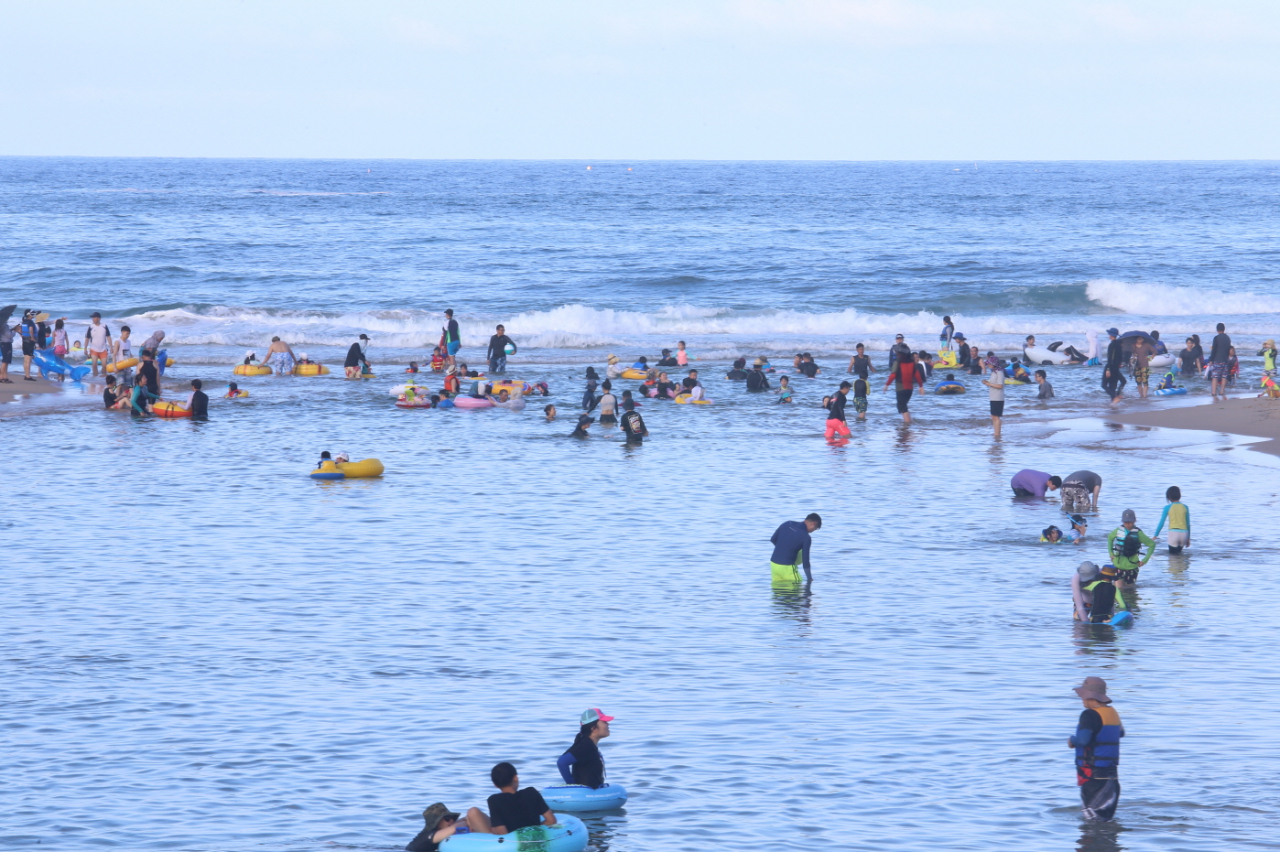 Vacationers enjoy time at Hwajinpo Beach. (Goseong County)