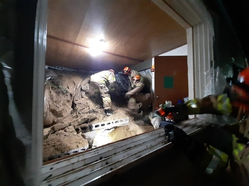 Firefighters try to rescue a 14-month-old baby buried in a mudslide in the southeastern city of Yeongju on Friday. (Gyeongbuk Fire Service Headquarters)