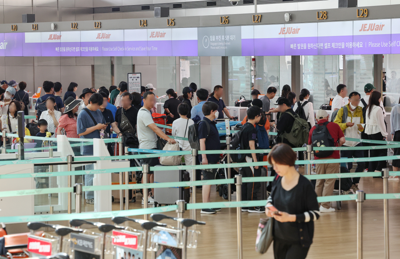 Passengers stand in check-in lines at Incheon Airport on May 22. (Yonhap)