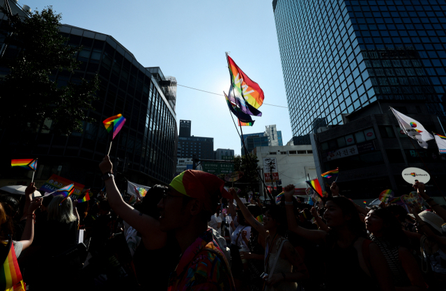 Participants of the 24th Seoul Queer Culture Festival wave rainbow flags during a parade in Euljiro, central Seoul, Saturday. (Yonhap)