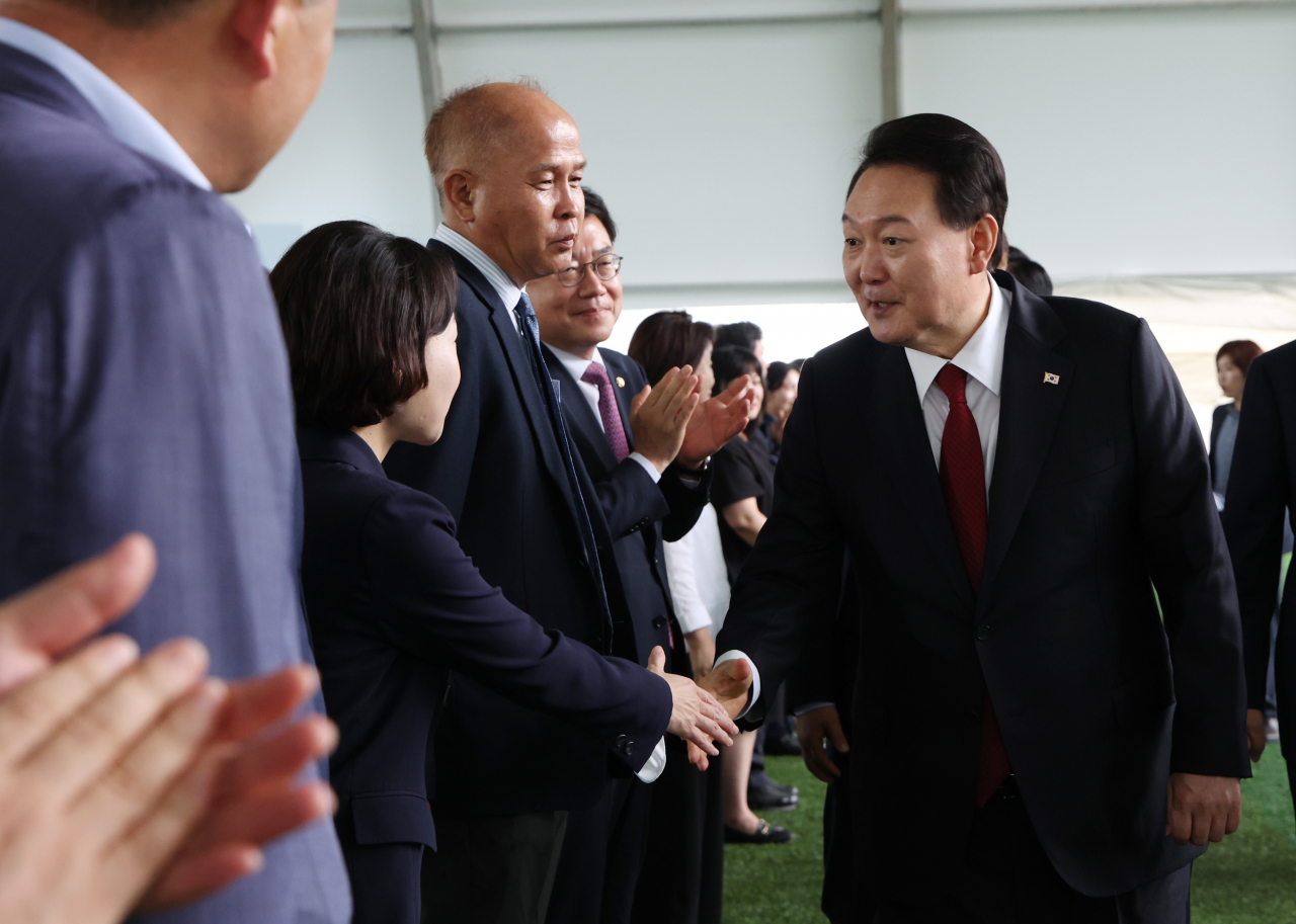 President Yoon Suk Yeol greets Democratic Party lawmaker Hong Jeong-min at the inaugural ceremony of a local event in Gyeonggi Province, June 30. (Yonhap)