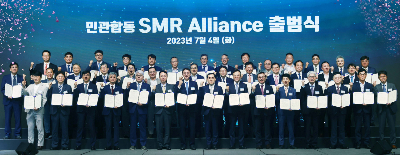 Trade, Industry and Energy Minister Lee Chang-yang (eigth from left, front row), SK Inc. CEO and Vice Chairman Jang Dong-hyun (ninth from left, front row) and Korea Hydro & Nuclear Power President and CEO Whang Joo-ho pose for a photo at the SMR alliance's inauguration ceremony, held in a Seoul hotel on Tuesday. (Ministry of Trade, Industry and Energy)
