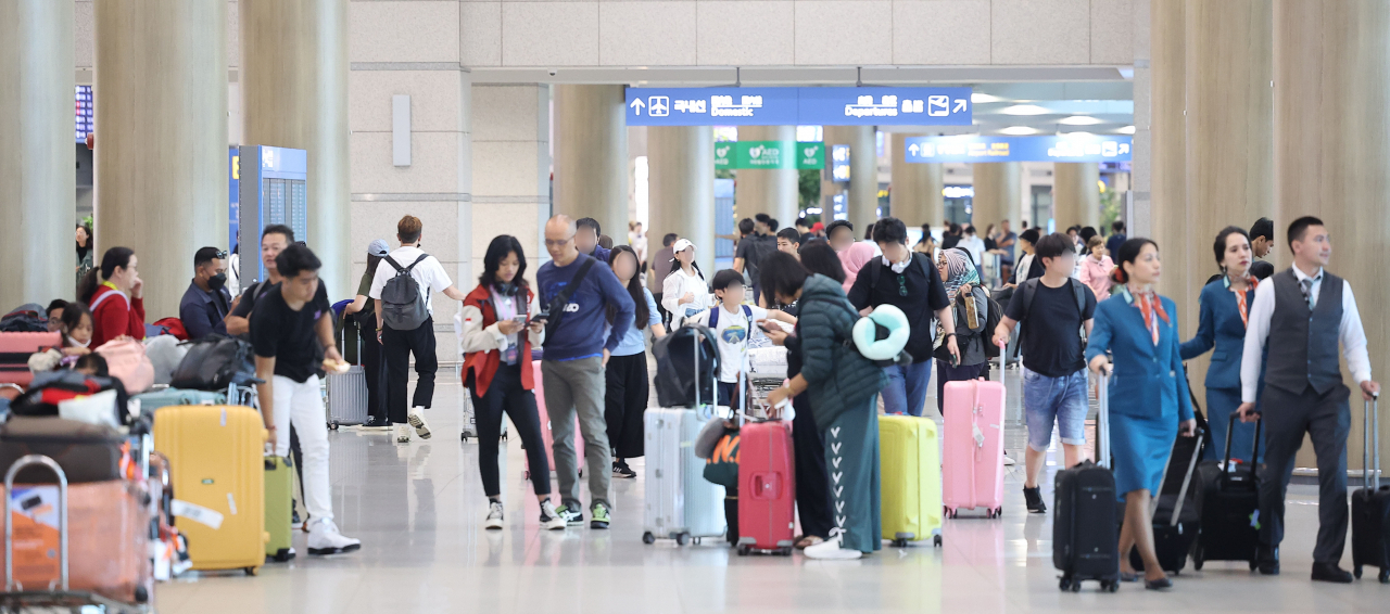 Tourists arrive at Incheon Airport on Sunday (Yonhap)