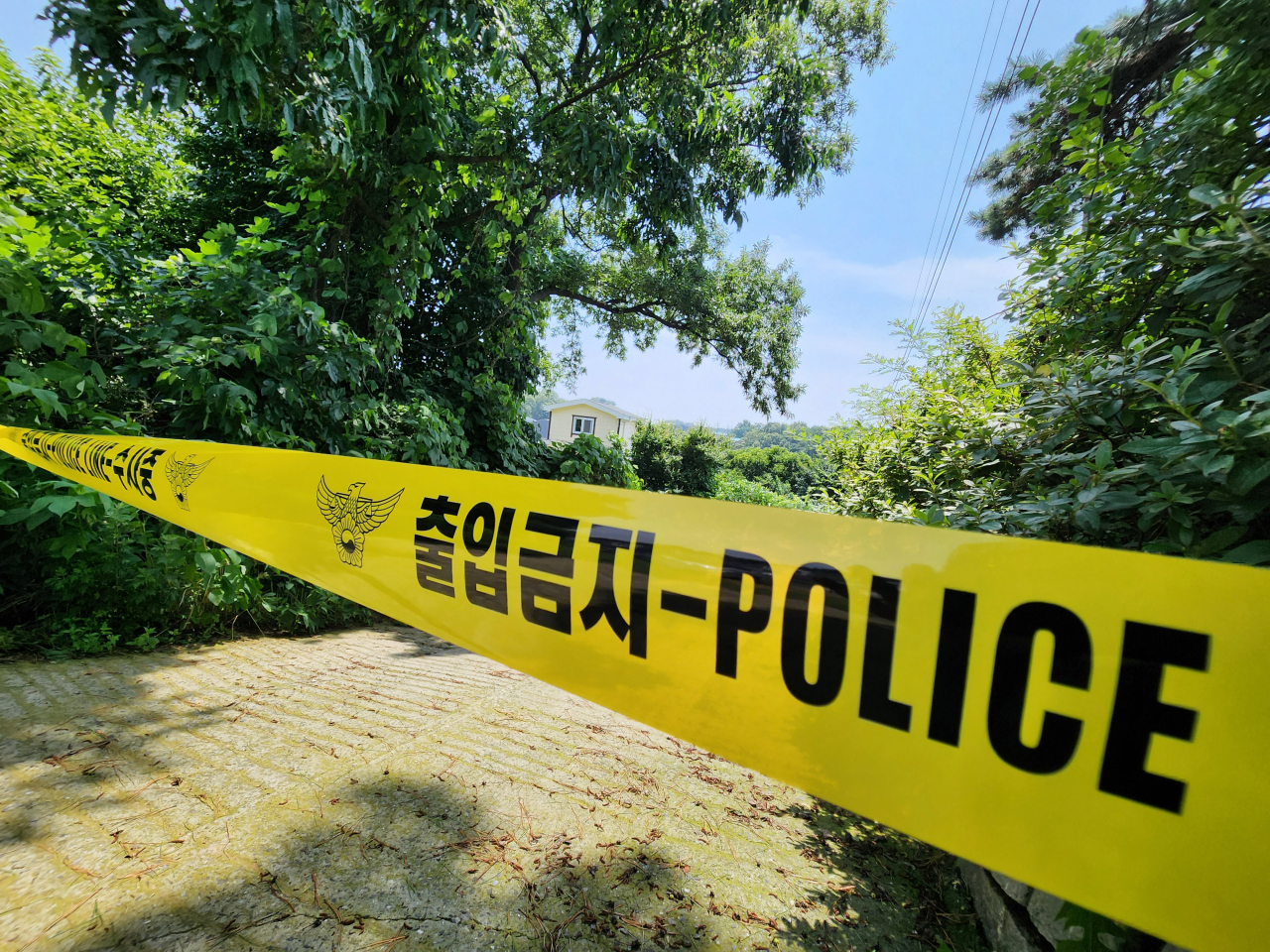 The vegetable garden where a woman is suspected of illegally burying her child is cordoned off on Thursday. (Yonhap)