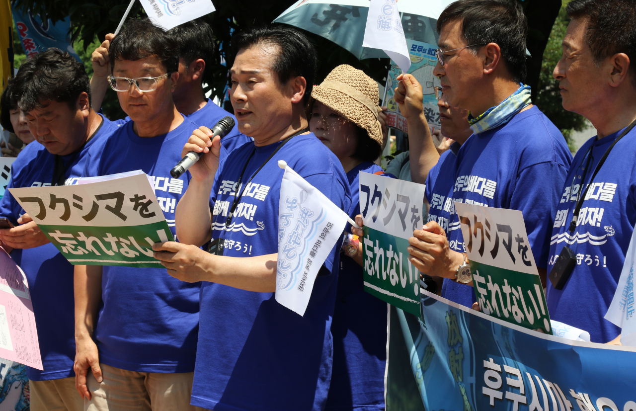 Democratic Party of Korea Rep. Ju Cheol-hyeon (third from left, front row) delivers a speech as they staged a protest with Japanese activists in front of Japanese Prime Minister Fumio Kishida's office in Tokyo on Monday. (Yonhap)