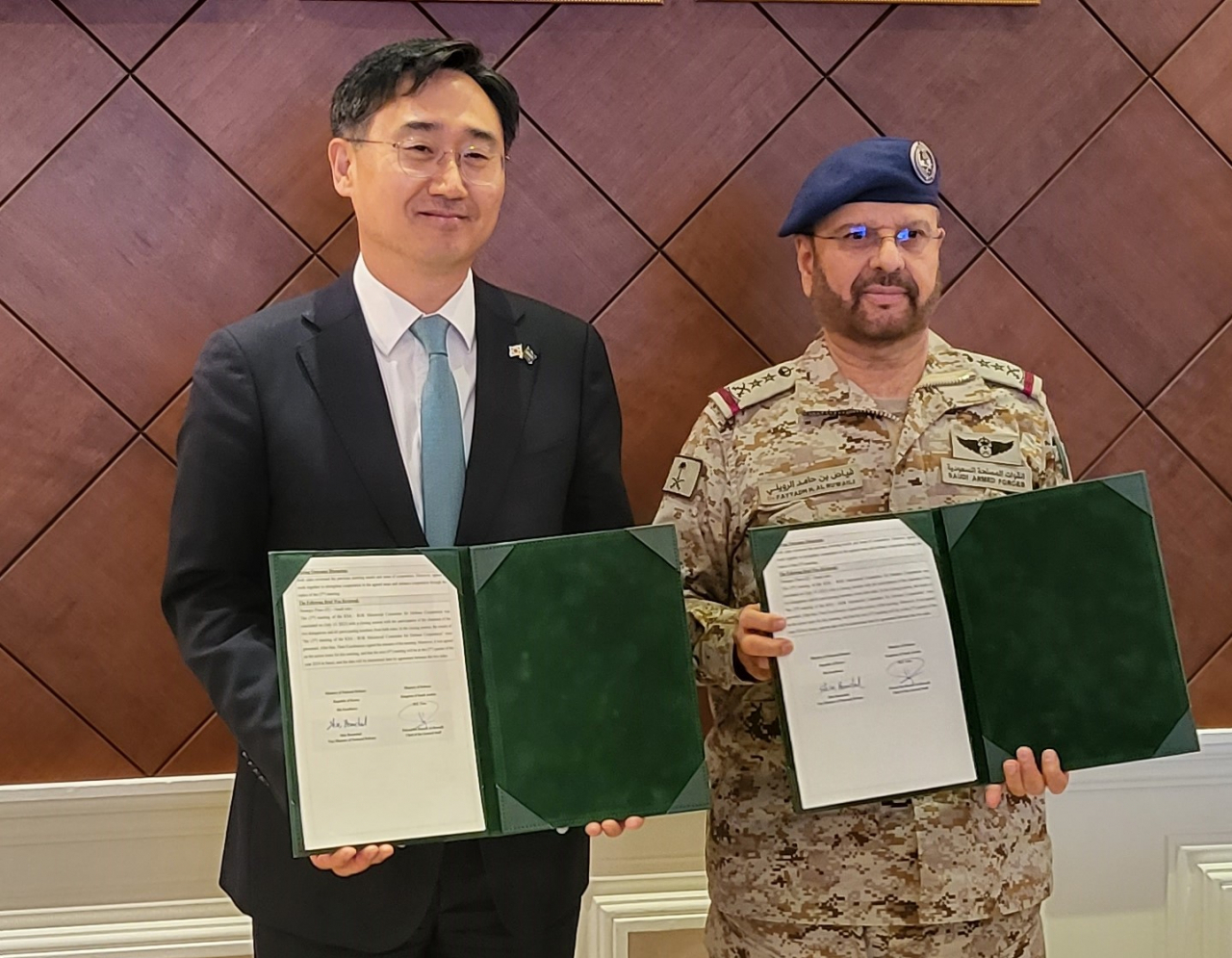 Vice Defense Minister Shin Beom-chul (left) and Fayyadh bin Hamed Al-Ruwaili, chairman of Saudi Arabia's General Staff, pose for a photo holding the minutes of their meeting in Riyadh on Monday. (Yonhap)