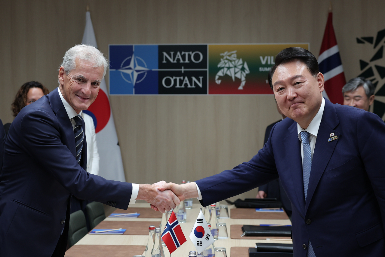 South Korean President Yoon Suk Yeol (right) poses for a photo with Norwegian Prime Minister Jonas Gahr Store during their talks at the venue of a NATO summit in Vilnius, Lithuania, on Tuesday. (Yonhap)