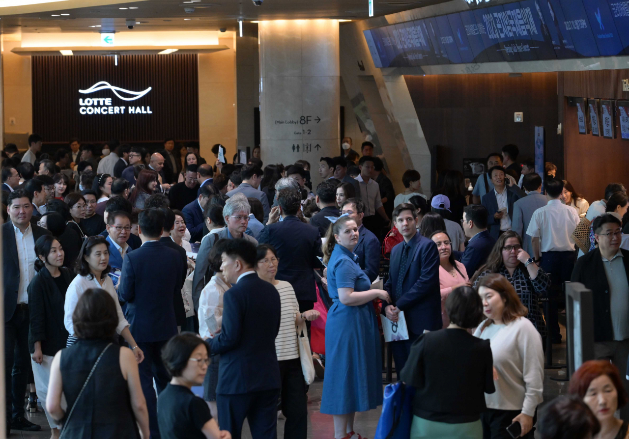 Concertgoers stand in the lobby of the Lotte Concert Hall in Jamsil, Seoul, ahead of the Opening Gala Peace Concert of the 2023 Gonjiam Music Festival on Monday. (Lee Sang-sub/The Korea Herald)