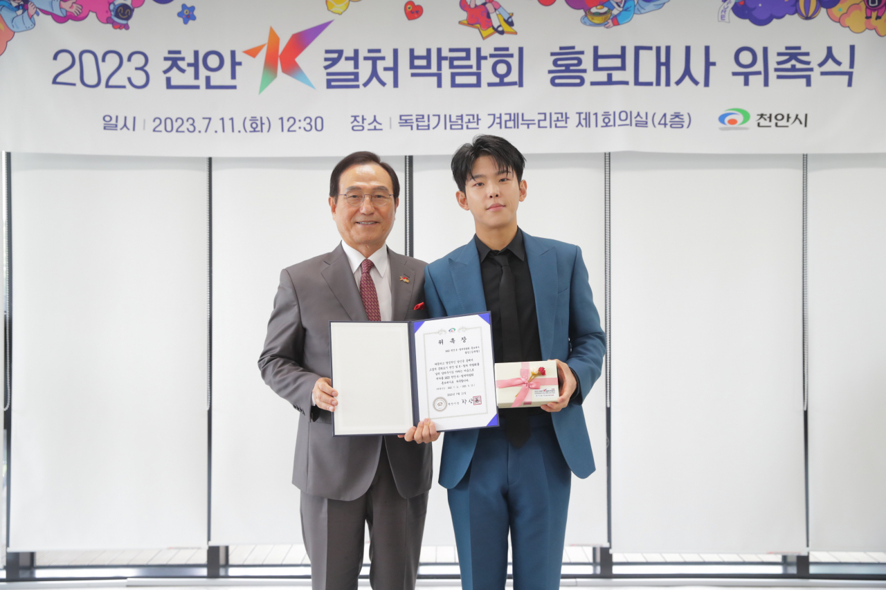 Cheonan Mayor Park Sang-don (left) and singer-songwriter Paul Kim pose for photos at the Independence Hall of Korea in Cheonan, South Chungcheong Province on Tuesday. (Cheonan City)