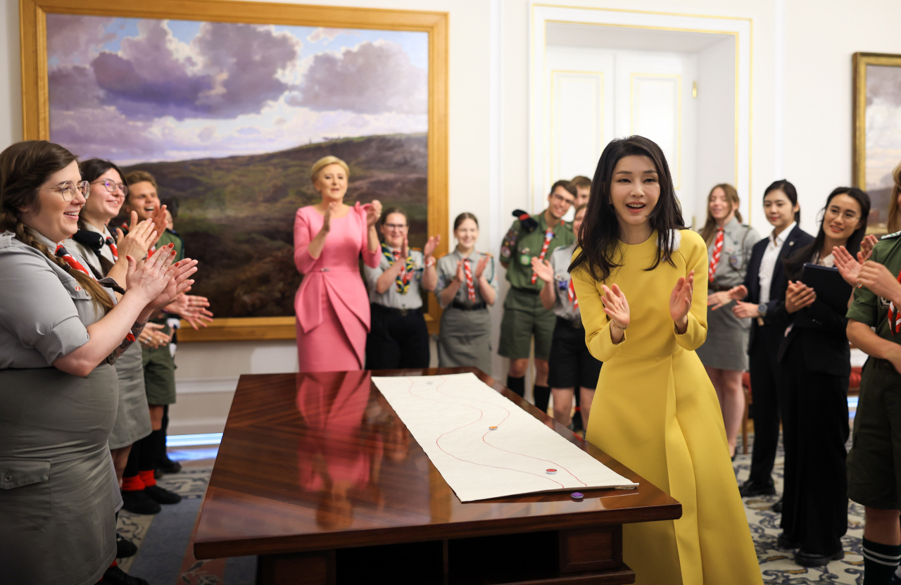 First lady Kim Keon Hee and Polish first lady Agata Kornhauser-Duda play a traditional Polish game with Polish scouts at Belvedere Palace in Warsaw, on Thursday. (Yonhap)