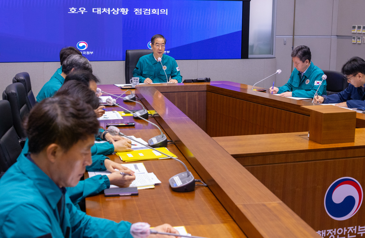 Prime Minister Han Deok-soo (rear) speaks during an emergency response meeting against heavy rains at the government complex in Seoul on Friday. (Yonhap)