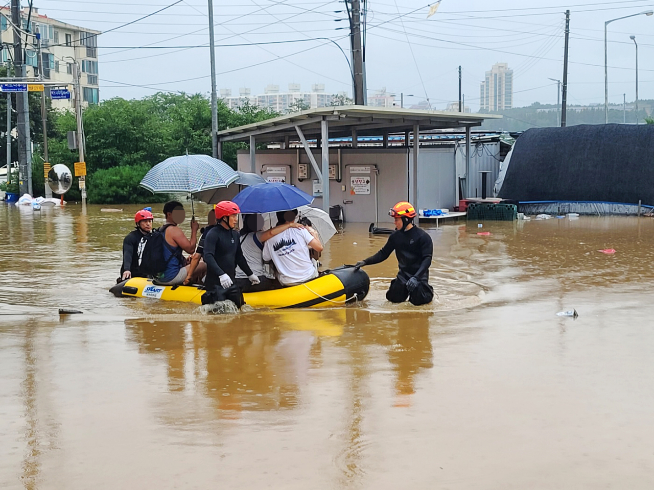 Rescuers evacuate residents on a flooded street in the central city of Gongju on Saturday, in this photo provided by a reader. (Yonhap)