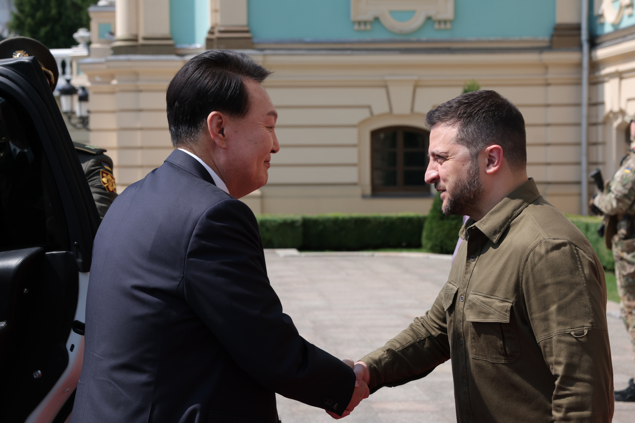 President Yoon Suk Yeol, who made a surprise visit to Ukraine, shakes hands with Ukrainian President Volodymyr Zelenskyy, ahead of the Korea-Ukraine summit held at the Mariinskyi Palace in Kyiv on Saturday. (Yonhap)