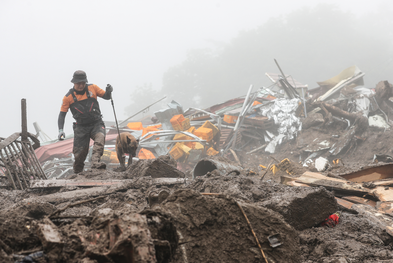 A rescue worker looks for survivors at Baekseok-ri in Yecheon, North Gyeongsang Province, Sunday. (Yonhap)