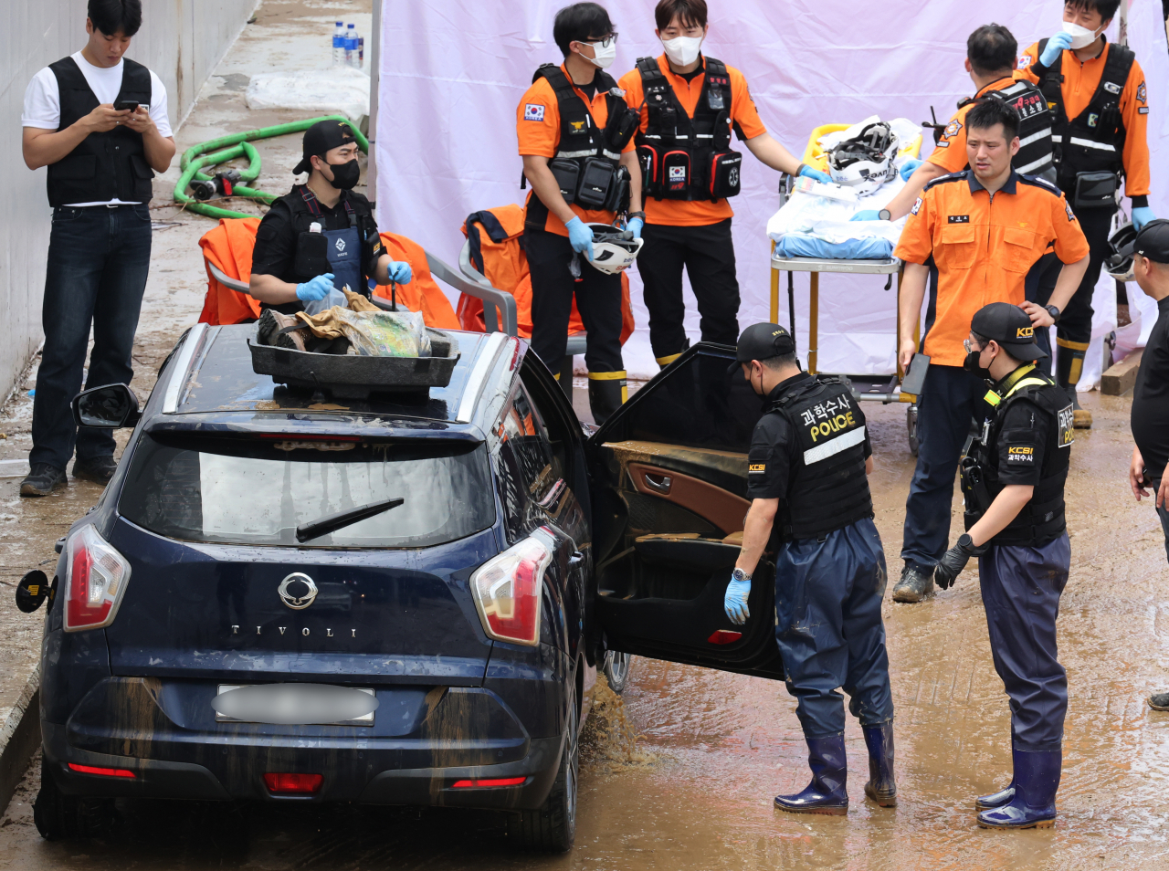 Investigators conduct probe into a car submerged due to flooded Gungpyeong 2 Underpass in Cheongju, North Chungcheong Province, on Monday. (Yonhap)
