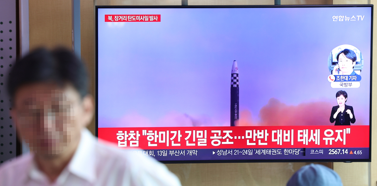 People watch a TV report on North Korea's launch of an intercontinental ballistic missile (ICBM) toward the East Sea at Seoul Station on July 12, 2023. (Yonhap)