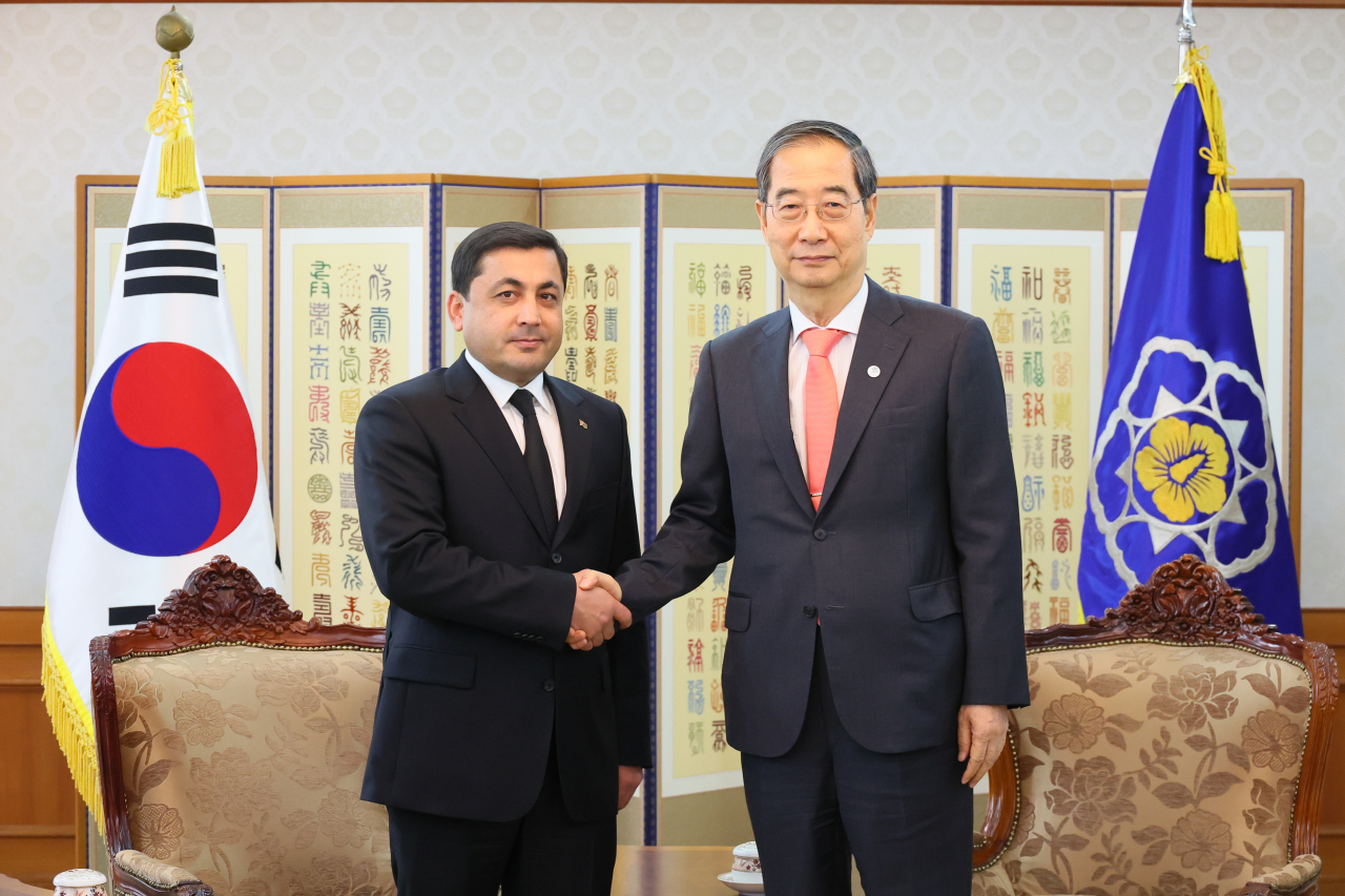 This photo shows South Korean Prime Minister Han Duck-soo (right) posing for a photo with Baymyrat Annamammedov, Turkmenistan's deputy prime minister for construction, industry, and electric power, at the government complex in Seoul on Monday. (Han's office)