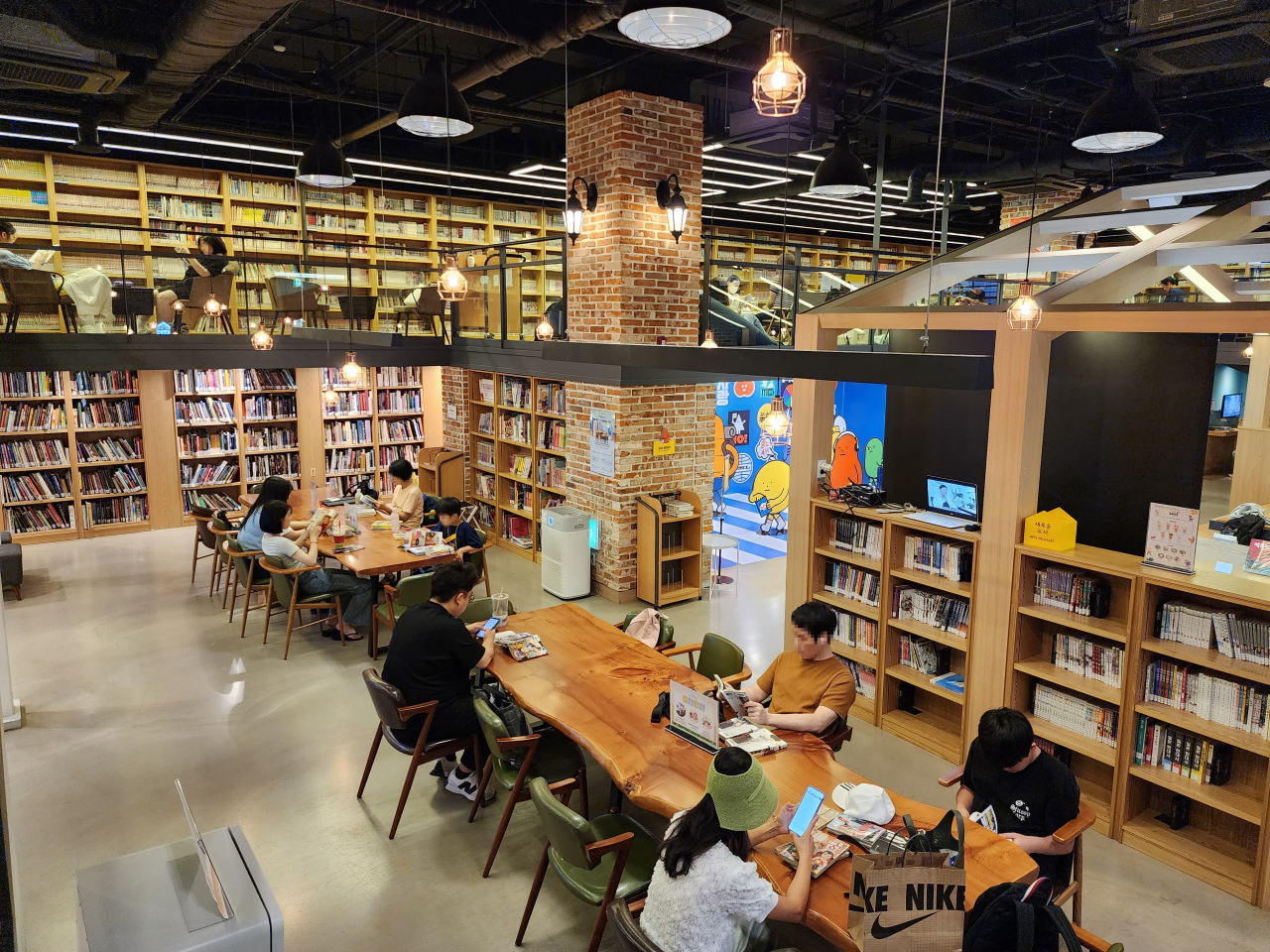 Visitors read manhwa at Comics Cafe. (Hwang Dong-hee/The Korea Herald)