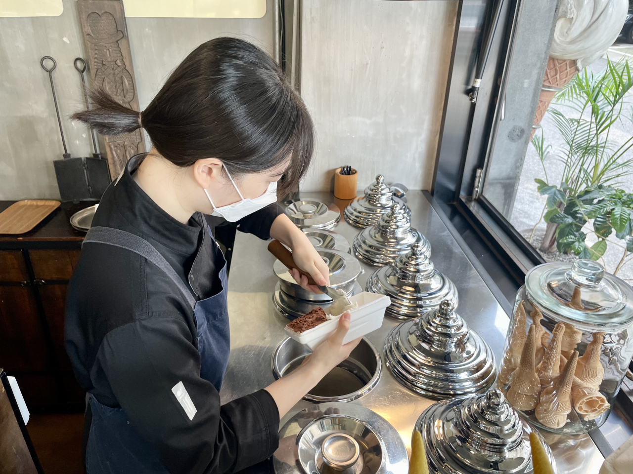 A staff scoops gelato at Cacao Boom. (Kim Da-sol/The Korea Herald)