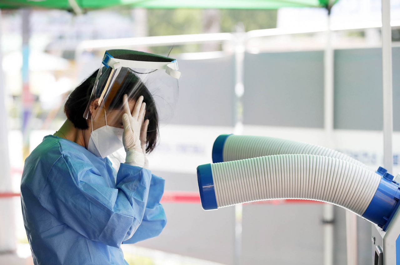 A medical worker stands in front of an air cooler at a public health center in Gwangju. (Yonhap)