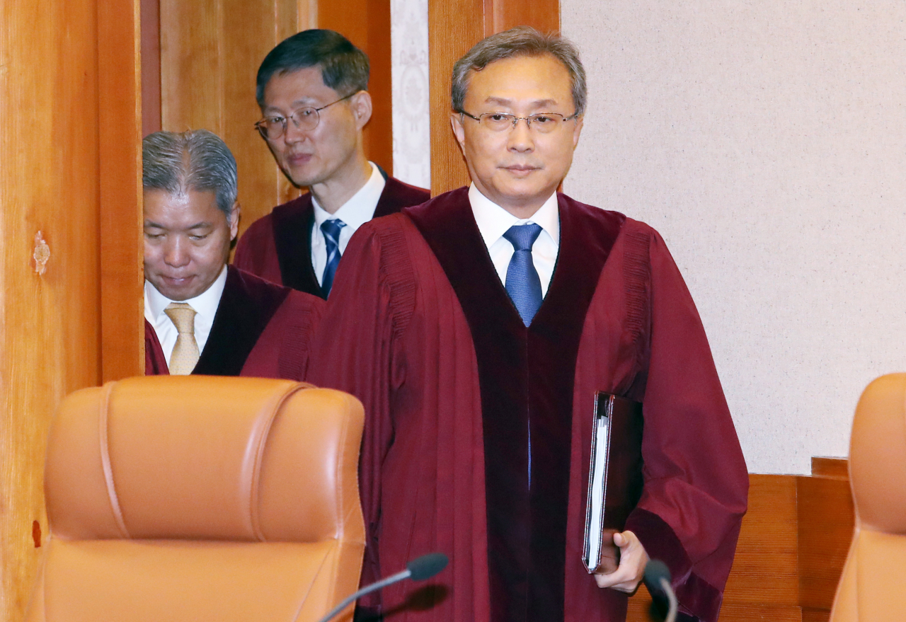 Constitutional Court Chief Justice Yoo Nam-seok (right) and other justices enter the courtroom on Tuesday. (Yonhap)
