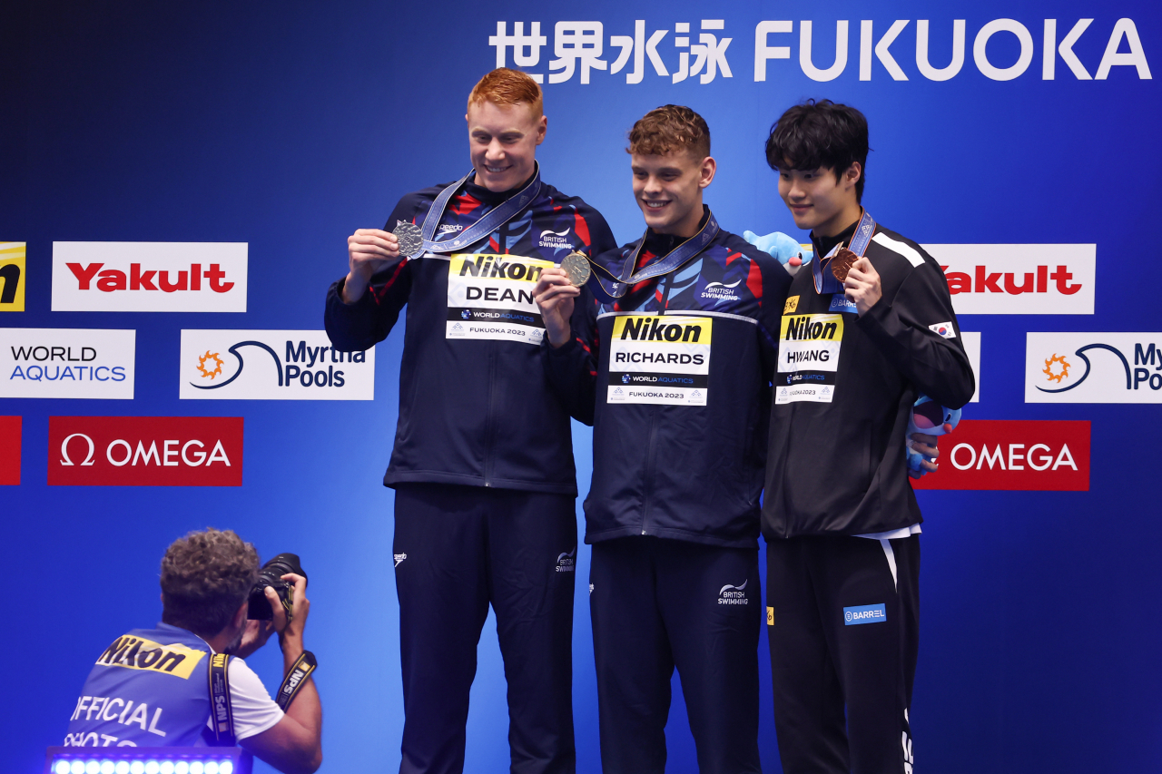 Hwang Sun-woo (right) of South Korea wins the bronze medal in the men's 200-meter freestyle at the World Aquatics Championships in Fukuoka, Japan, on Tuesday. (Yonhap)