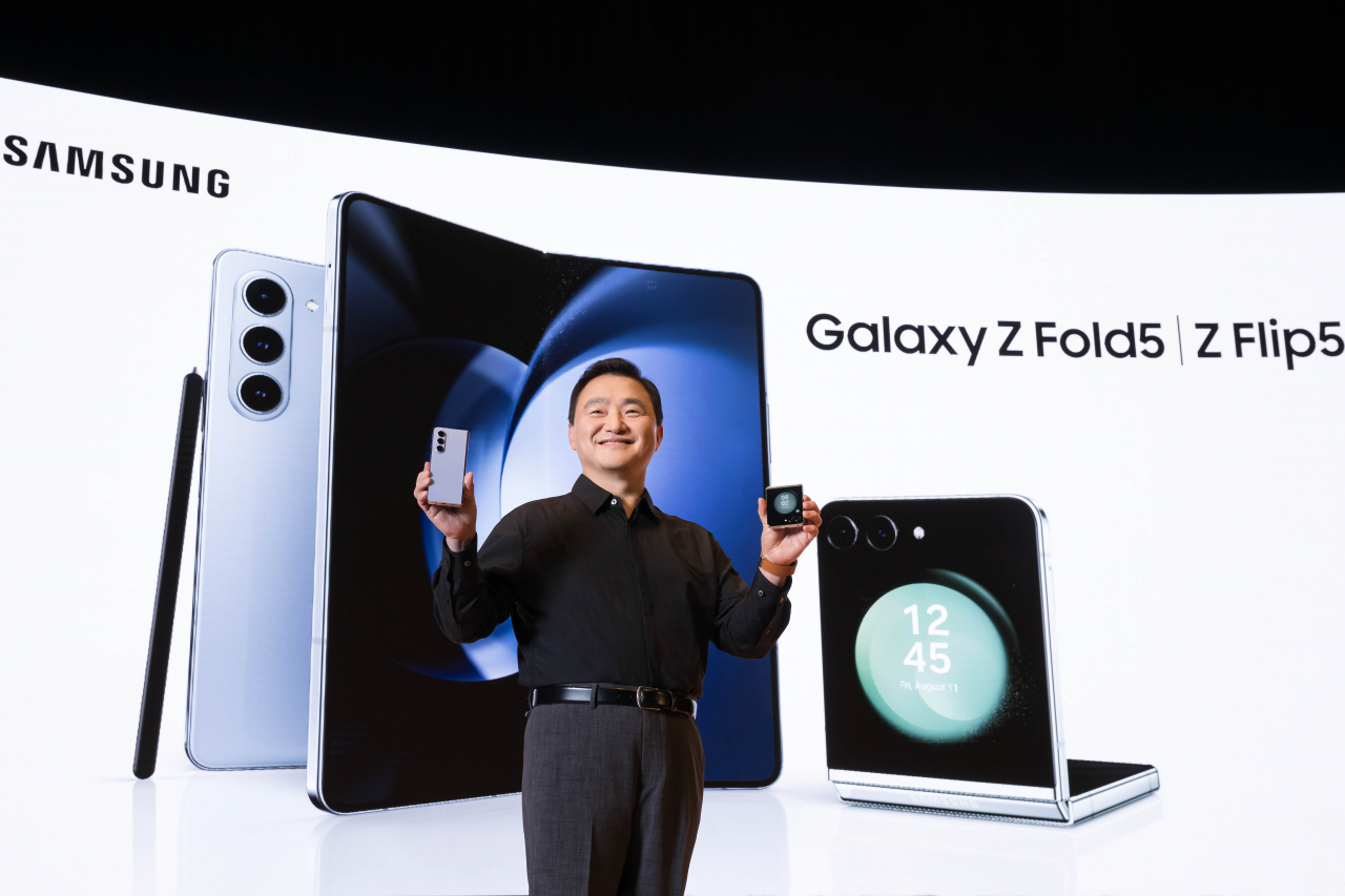 Samsung Electronics President Roh Tae-moon poses with the new Galaxy foldable smartphones at Coex in southern Seoul, Wednesday. (Samsung Electronics)