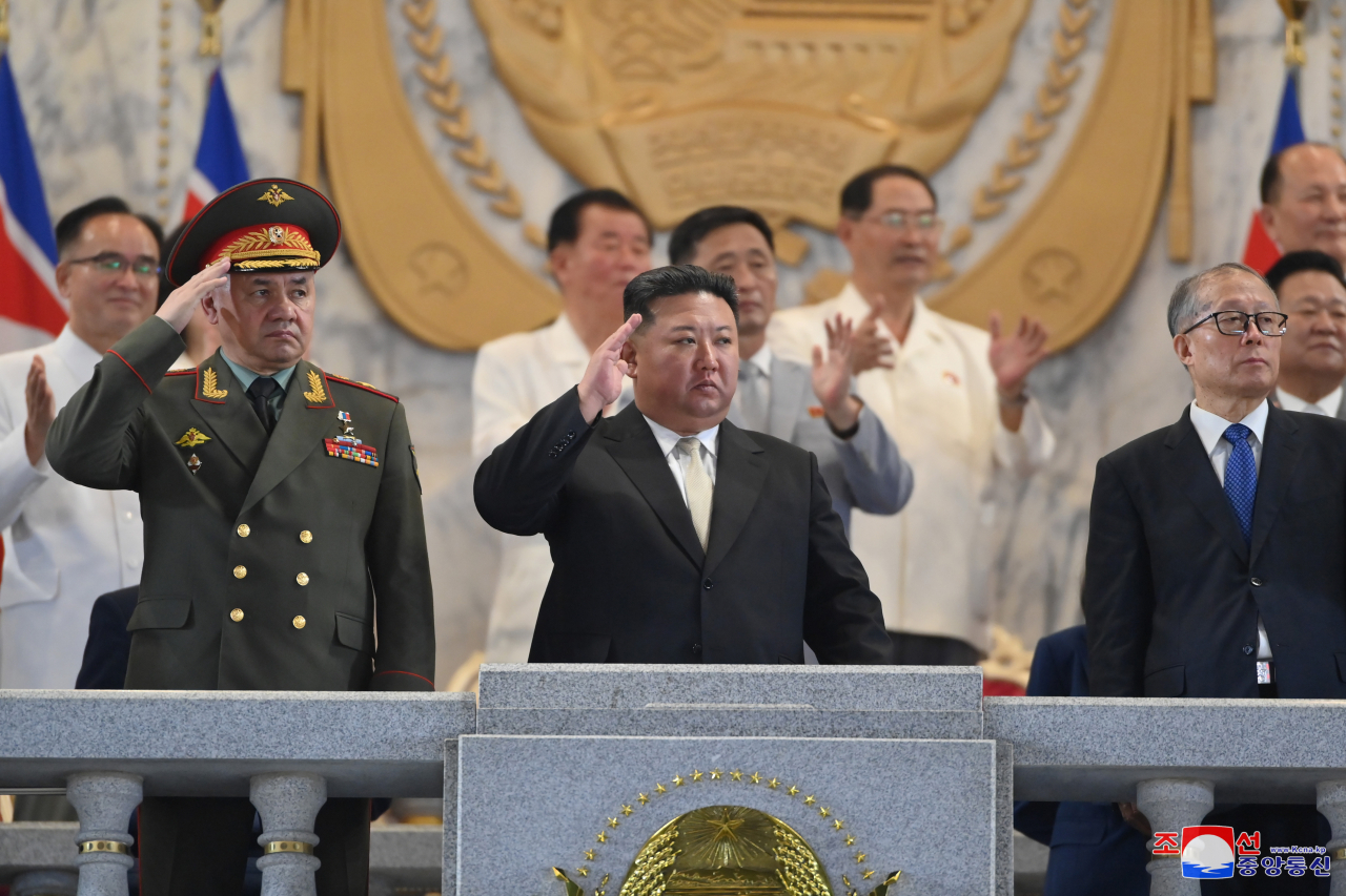North Korean leader Kim Jong-un (center), alongside Russian Defense Minister Sergei Shoigu (left) and Chinese Communist Party politburo member Li Hongzhong (right), observes a military parade at Kim Il-sung Square in Pyongyang on Thursday, to mark the 70th anniversary of the signing of the armistice that halted the 1950-53 Korean War, in this photo released the next day by North Korea's official Korean Central News Agency. (Yonhap)