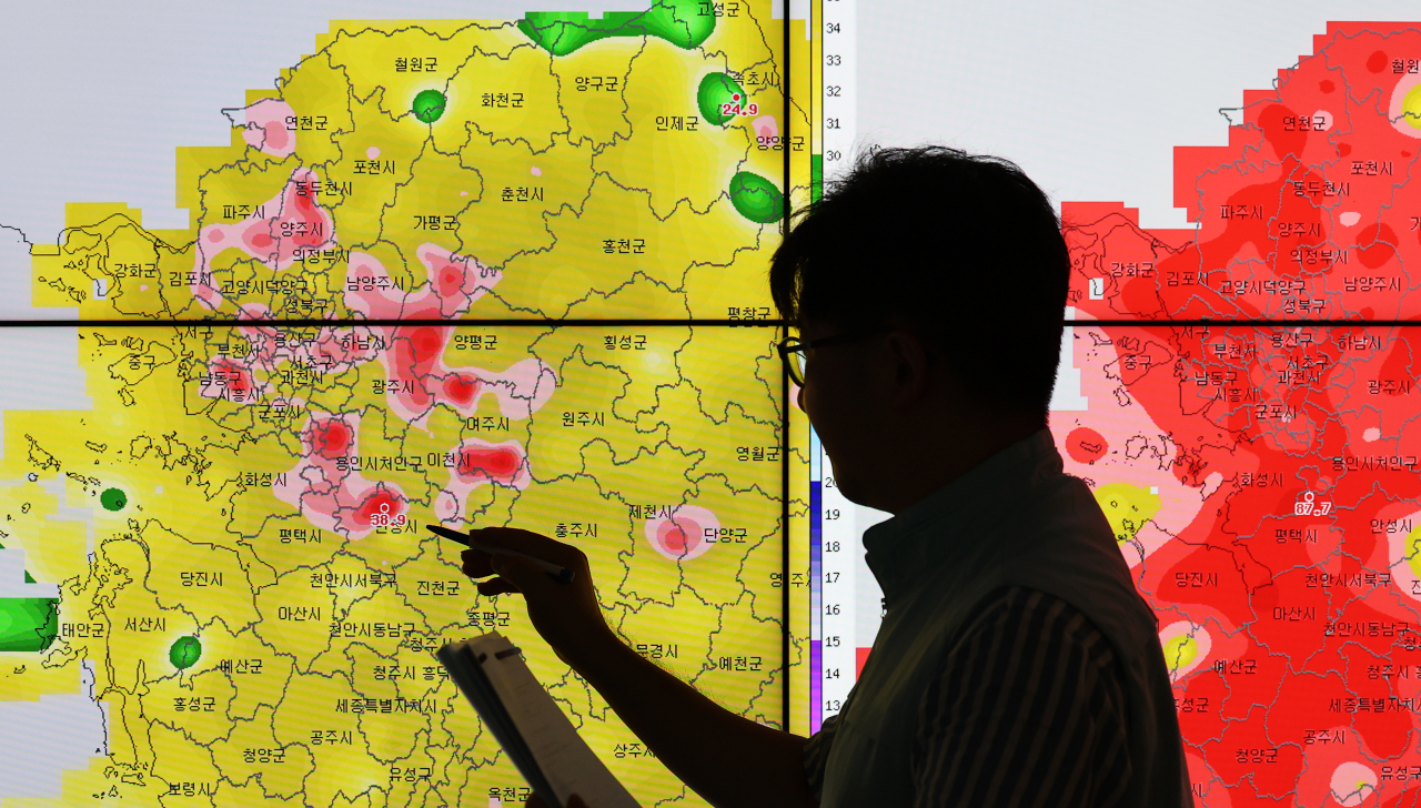 A weather forecaster looks at temperatures across South Korea at the Korea Meteorological Administration in Suwon, Gyeonggi Province, on Sunday, when heat wave alerts were issued in most parts of South Korea. (Yonhap)