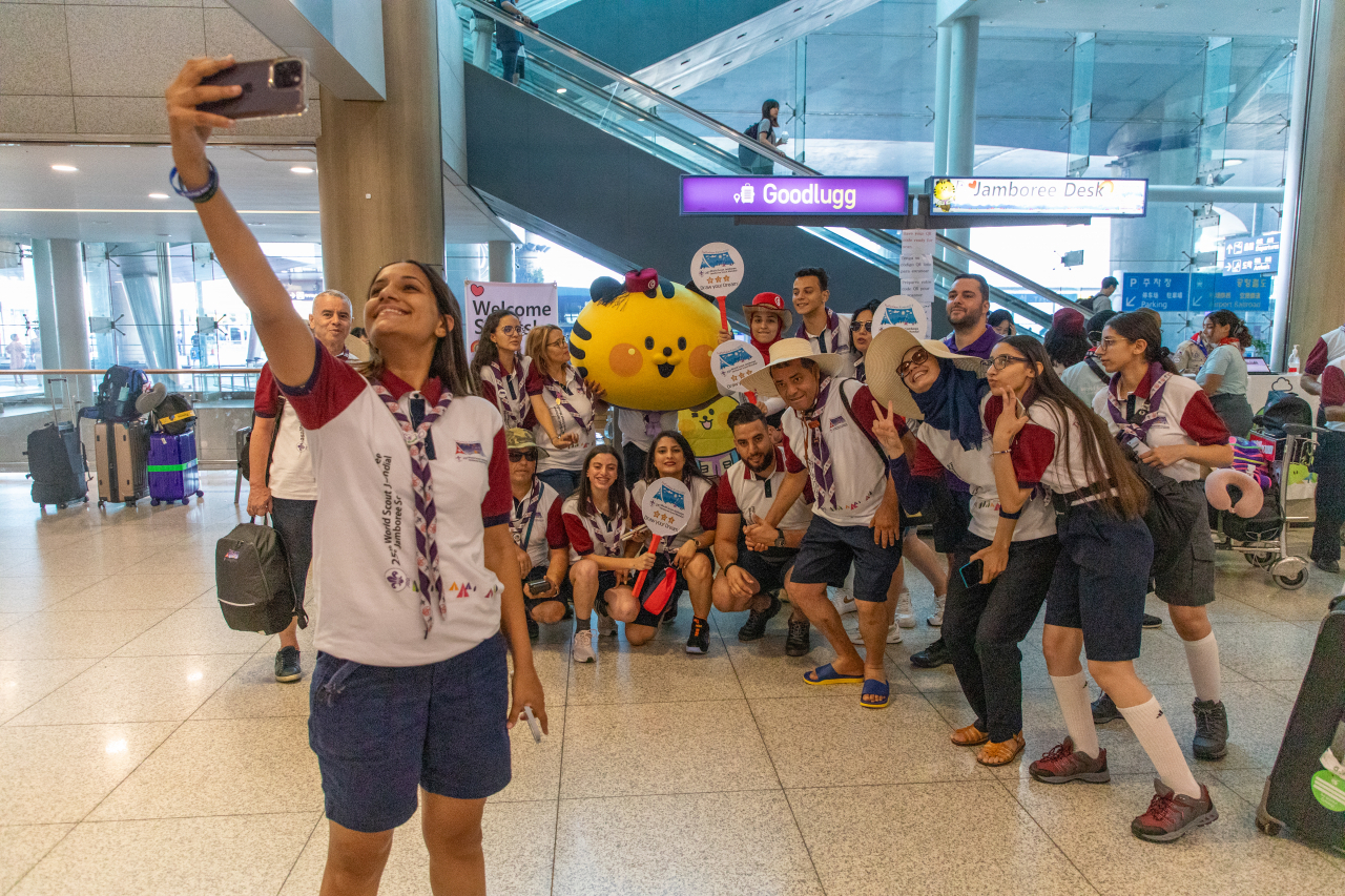 Scouts take picture with the 25th World Scout Jamboree mascot Saebeomi at Incheon Airport, Monday. (Jamboree Committee)