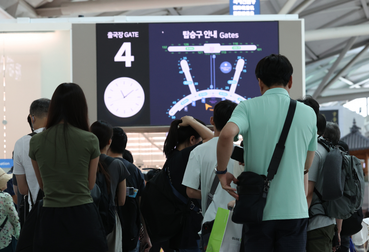 This photo shows travelers waiting to get a security check to enter the duty-free zone and take a flight in Incheon Airport on July 28. (Yonhap)