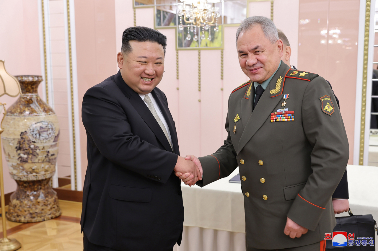North Korean leader Kim Jong-un (left) shakes hands with Russian Defense Minister Sergei Shoigu during their meeting at the headquarters of the Workers' Party of Korea's Central Committee in Pyongyang on July 26. (KCNA)