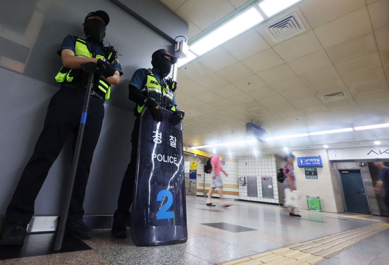 Police officers are stationed at Seohyeon Station in Bundang, Gyeonggi Province, Friday, a day after a man launched an attack that injured 14 people. (Yonhap)