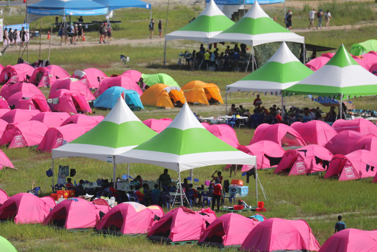 Participants of the 2023 Saemangeum World Scout Jamboree gather in the shade of a tent at the Jambyeori campsite in Buan-gun, North Jeolla Province on Friday. (Yonhap)