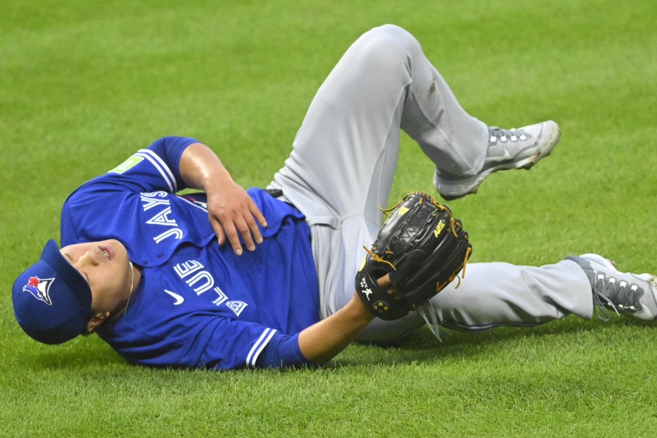 Ryu Hyun-jin of the Toronto Blue Jays drops to the ground in pain after taking a line drive off his right knee during the bottom of the fourth inning of a Major League Baseball regular season game against the Cleveland Guardians at Progressive Field in Cleveland on Monday. (Yonhap)
