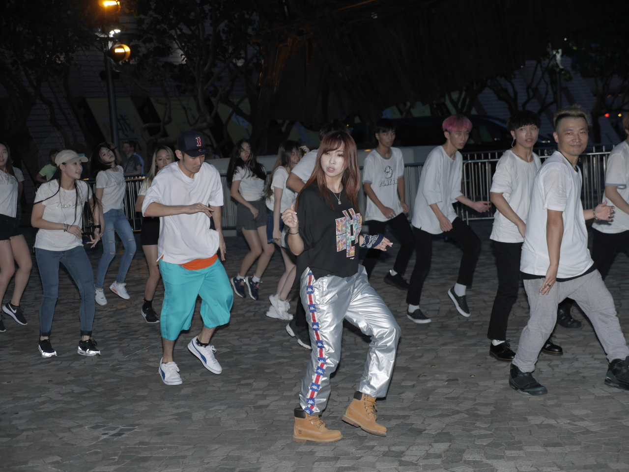 Minzy (center) of 2NE1 appears in a flash mob dance with FJDC director Kenny Ng Ka-wai (far right) in the Tsim Sha Tsui district in Hong Kong in September 2017. (Courtesy of HK01)