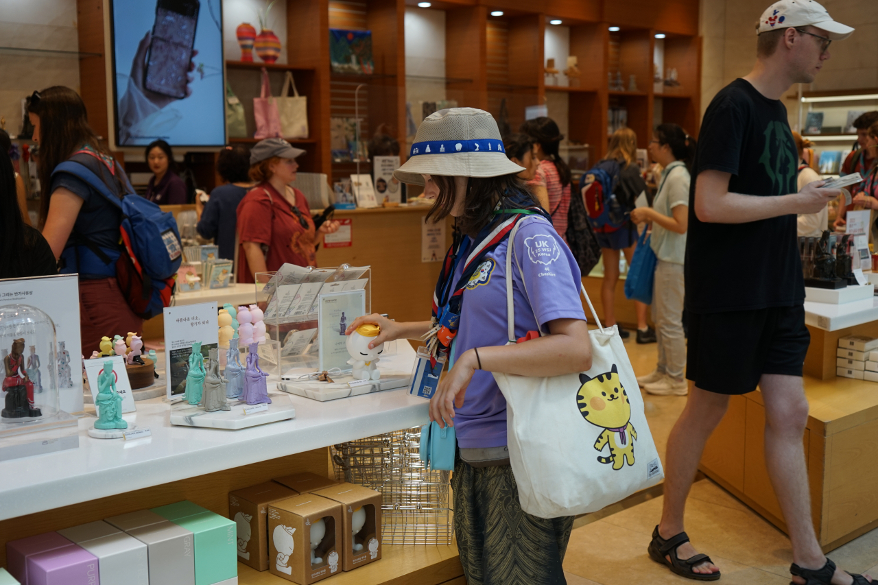 A Jamboree participant looks through items on display at the National Museum of Korea's souvenir shop in Seoul on Tuesday. (NMK)