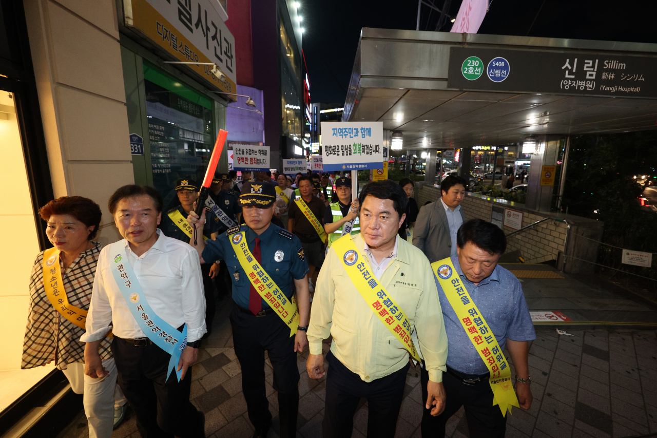 Related organizations including Gwanak Police Station, local merchants’ associations and voluntary night guards conduct a crime prevention campaign in Sillim-dong, Gwanak-gu, Seoul on Monday. (Yonhap)