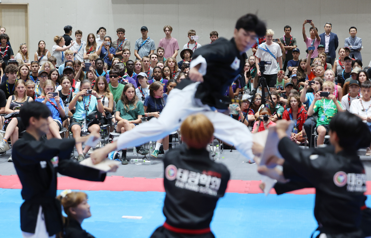 Attendees of the ongoing World Scout Jamboree watch a taekwondo practitioner perform at Sungkyunkwan University in Seoul on Wednesday, after leaving their campsite in the Saemangeum reclamation area in Buan, North Jeolla Province, on South Korea's west coast, the previous day due to the approaching Typhoon Khanun. (Yonhap)
