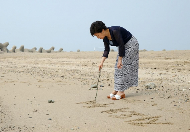 Ex-President Park Geun-hye is seen on the beach near her vacation home in Geoje, South Gyeongsang Province, on July 30, 2013. (The presidential office during Park's tenure)