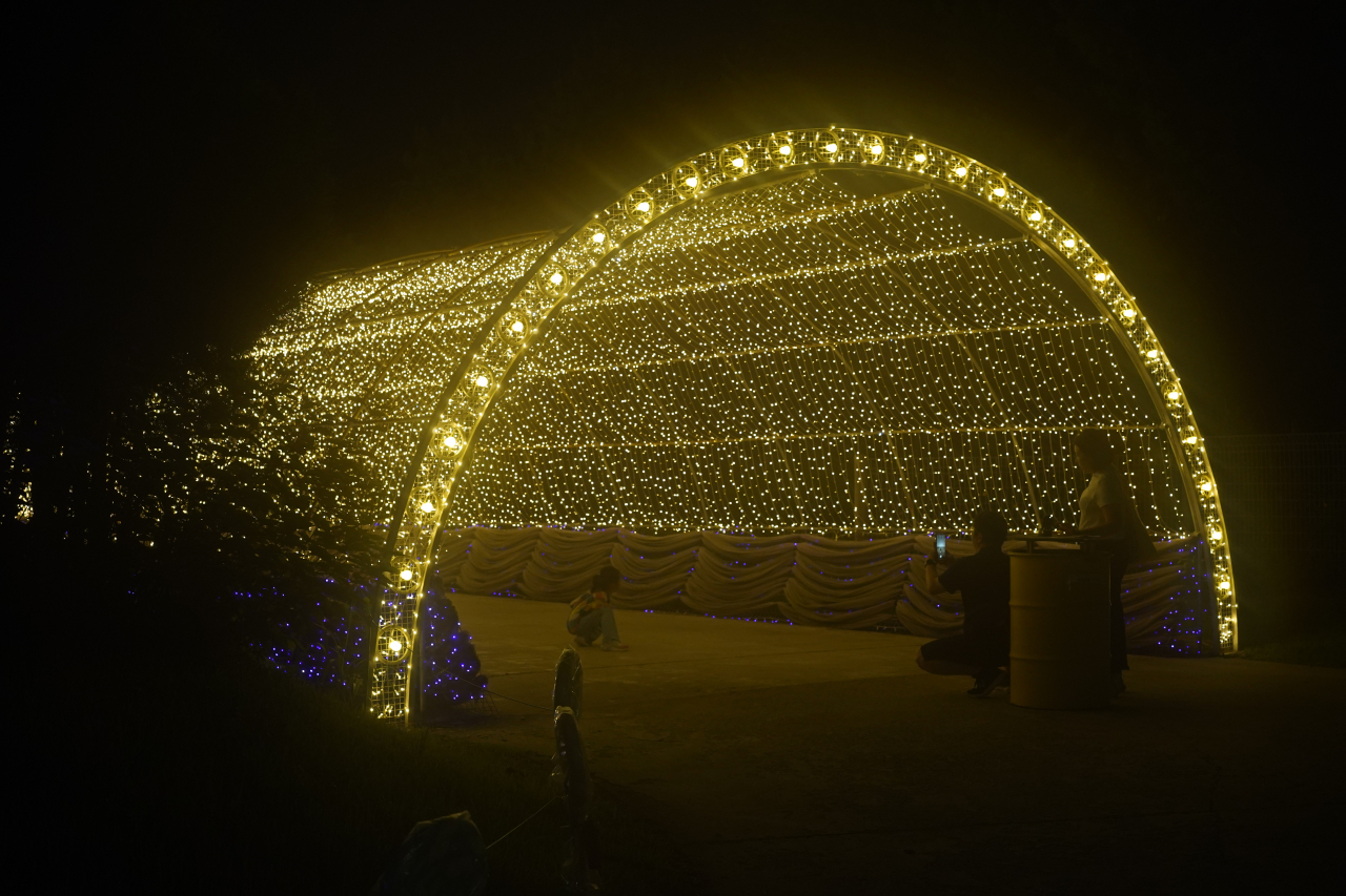 A family enjoys the lighted tunnel at Deokpyeong-Eco Service Area in Icheon, Gyeonggi Province on July 27. (Lee Si-jin/The Korea Herald)