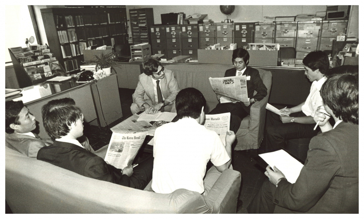 The Foreign Ministry's United Nations division officials discuss international affairs while reading The Korea Herald.