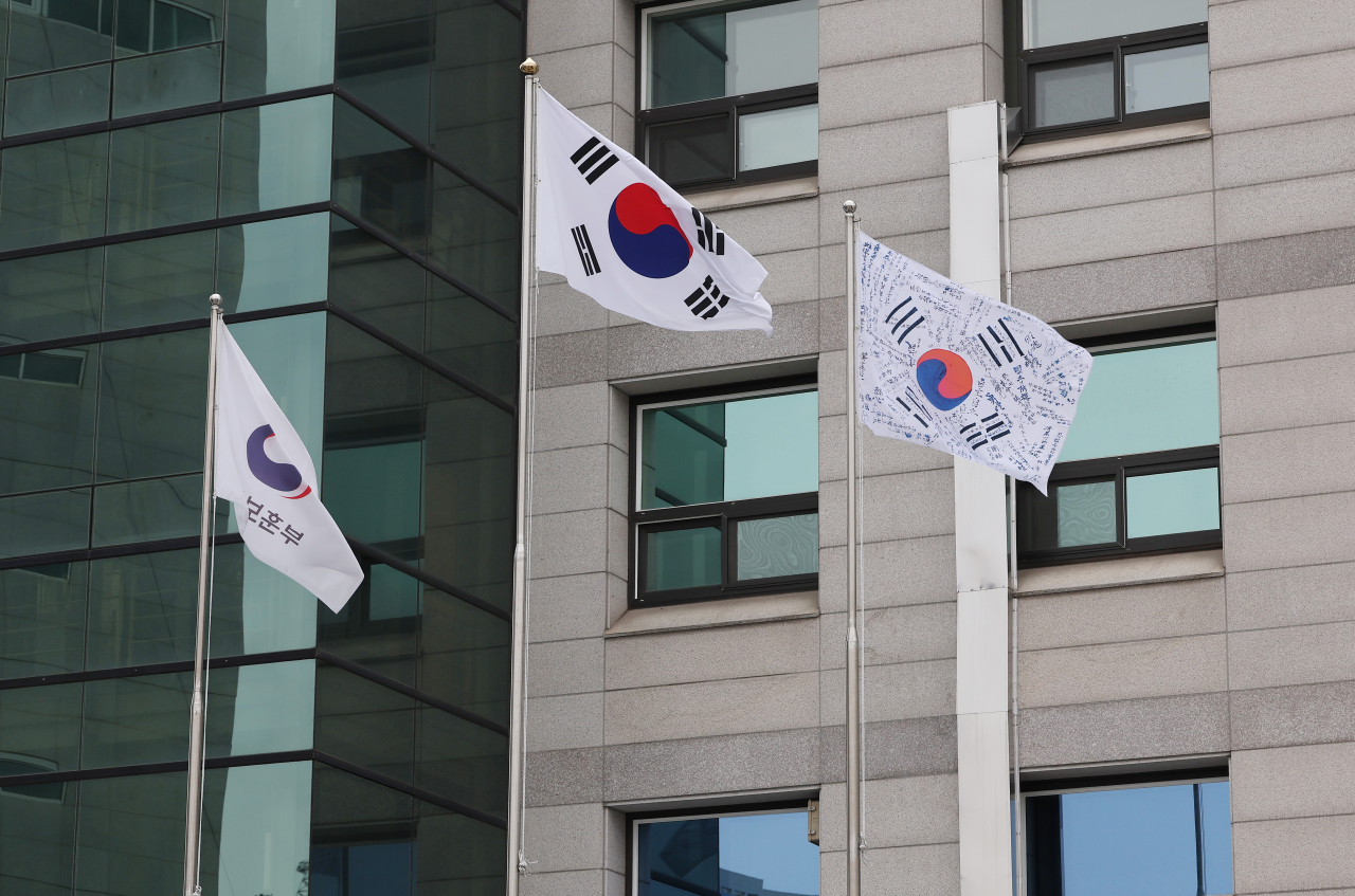 Two South Korean national flags are hoisted outside a building affiliated with the veterans ministry on Sunday. The flag on the right displays the autographs of independence fighters. (Ministry of Patriots and Veterans Affairs)