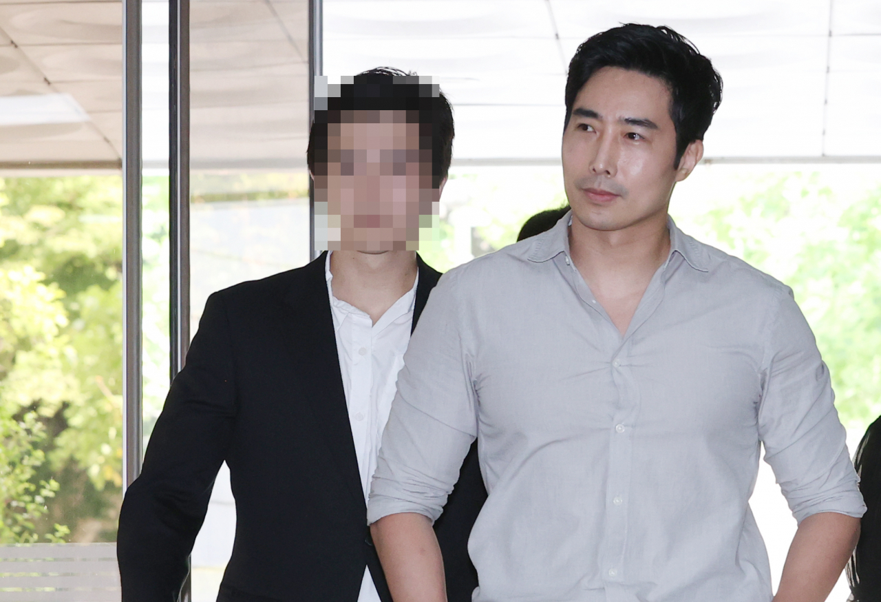 Rhee Keun (right) arrives at the Seoul Central District Court in southern Seoul on Thursday to attend his sentencing hearing. (Yonhap)