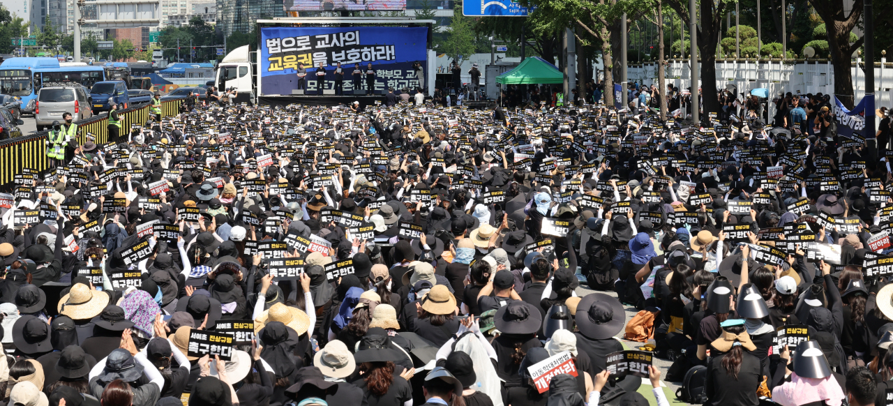 Teachers hold a rally in Seoul's Gwanghwamun Square calling for teachers' rights to be protected by law on Aug. 5. (Yonhap)